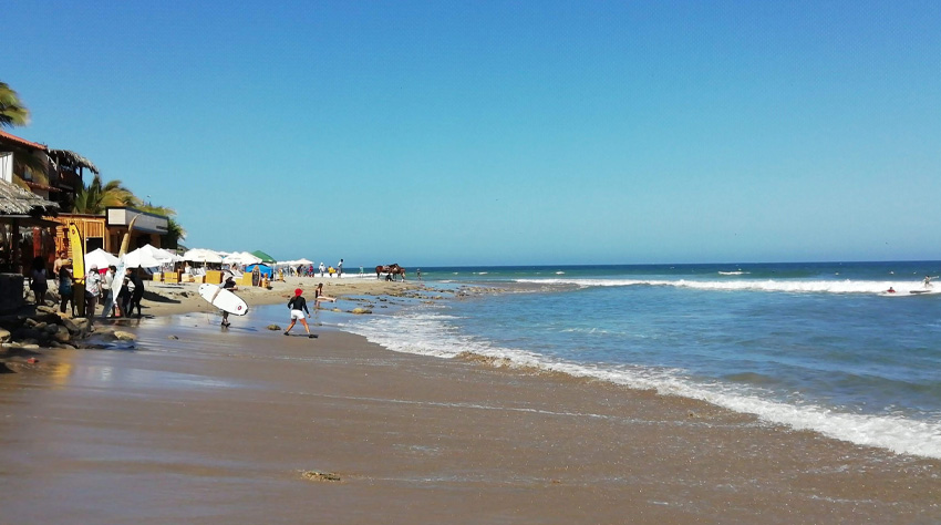 Playa Máncora Piura con surfistas y restaurantes frente al mar