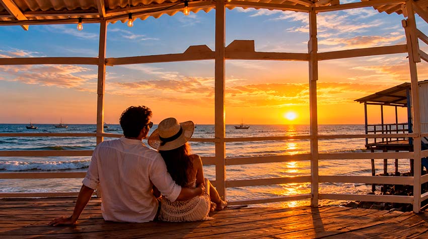 Pareja disfrutando del atardecer frente al mar en playa Colán